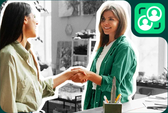 Dos mujeres sonrientes dándose la mano
